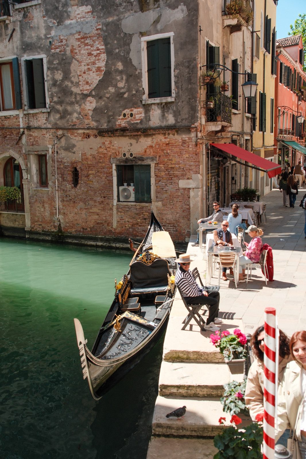 Gondolier resting beside a canal café in Venice