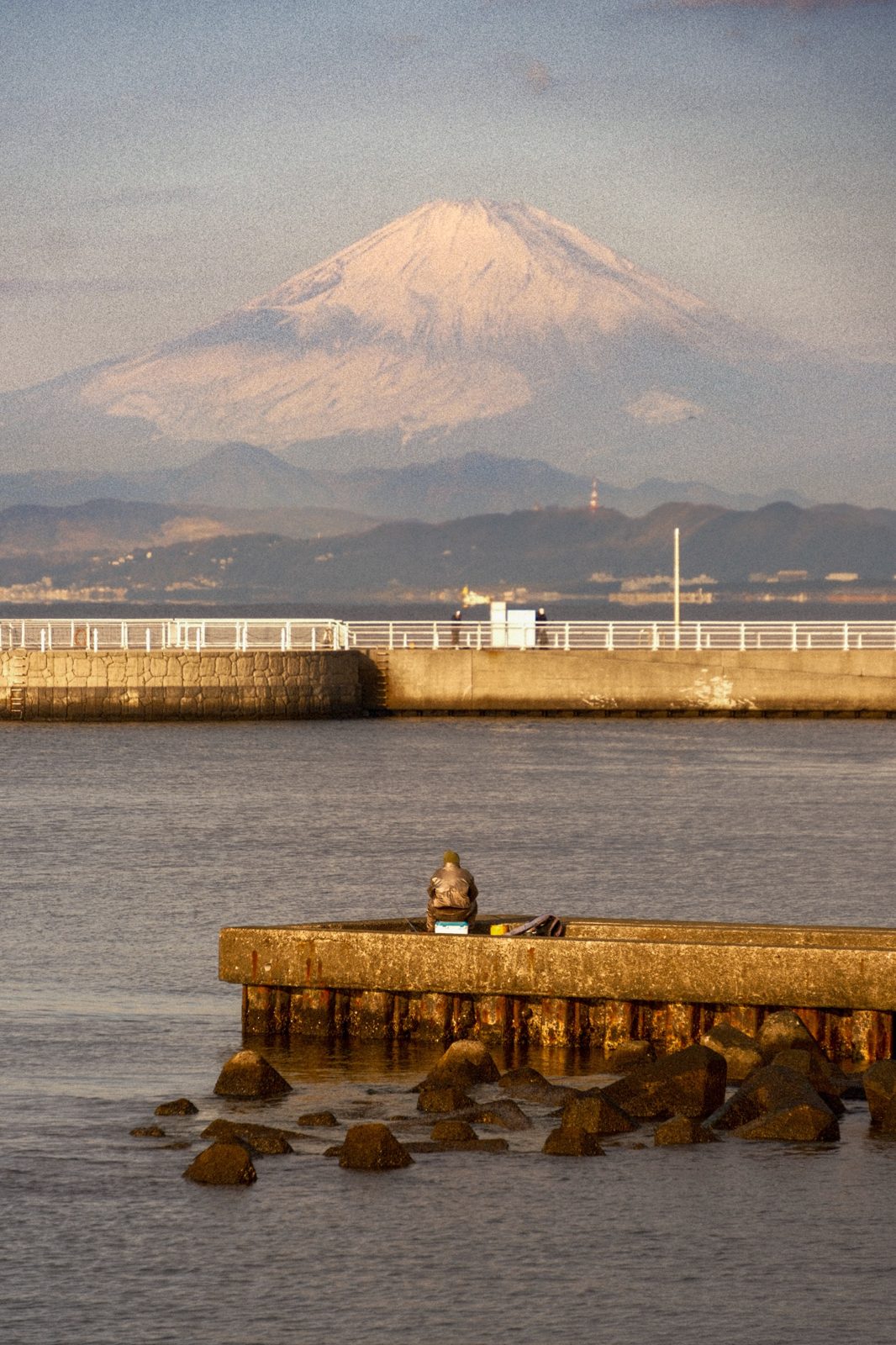 Mount Fuji at golden hour behind a fisherman in Enoshima